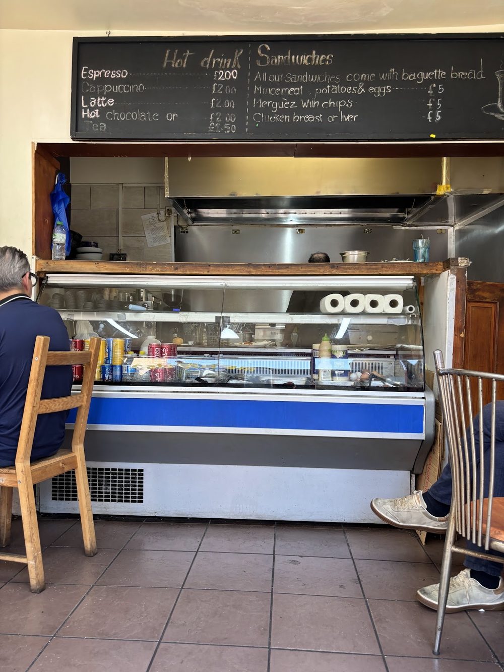Inside the shop: the servery, stools along the window and customers sitting in.
