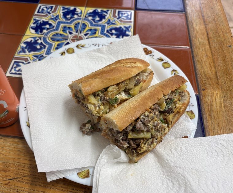 Baguette cut in half on a paper-lined plate.
